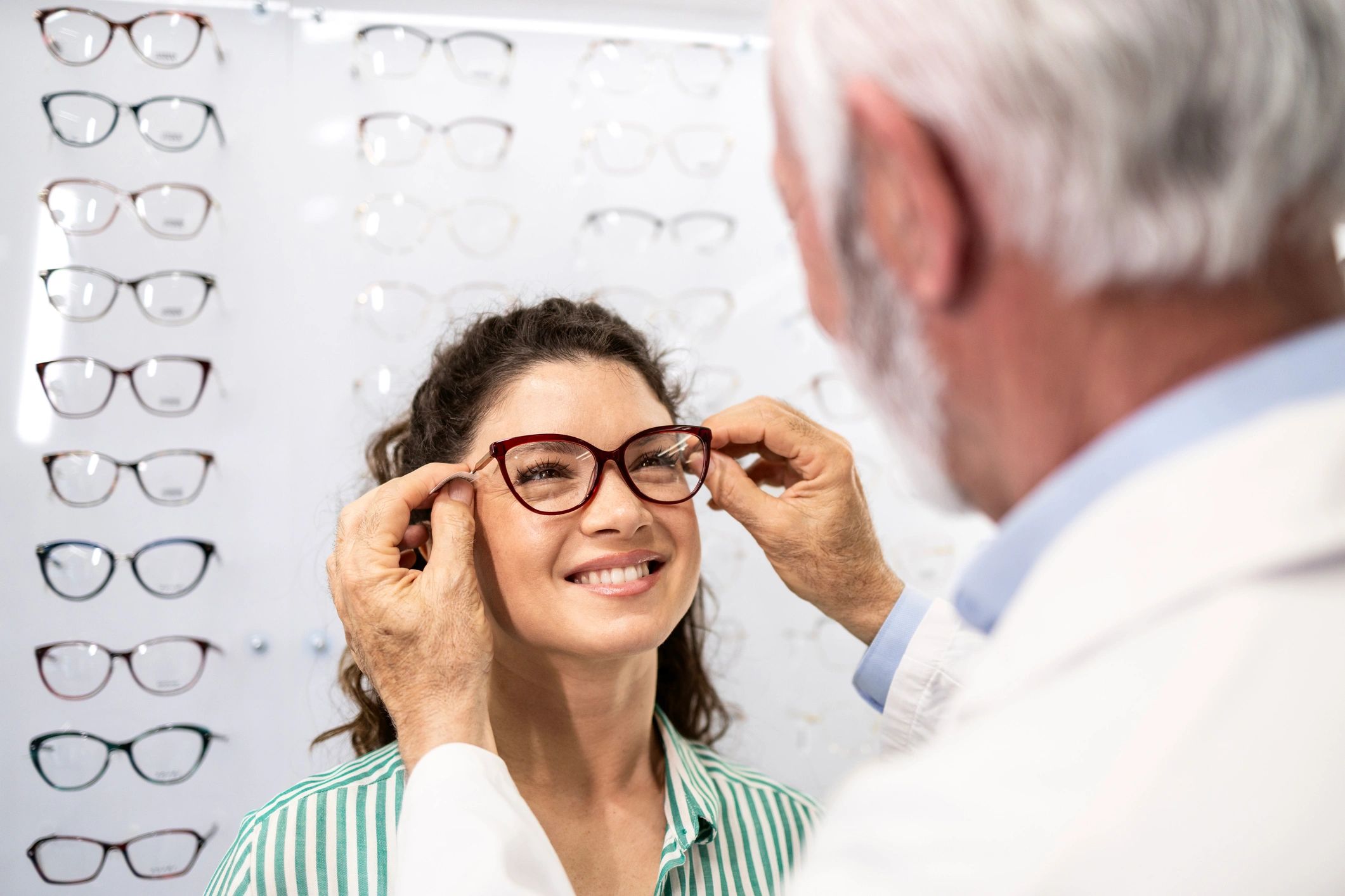 optometrist helping patient choose glasses